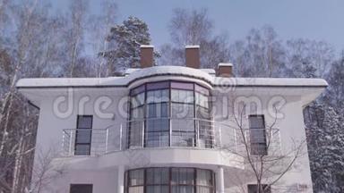 外观美丽的白色现代<strong>设计家居</strong>在冬天的雪树和蓝色的晴空背景。 库存录像。 二.